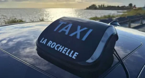Lumineux Taxi La Rochelle sur un véhicule au bord de l’océan
