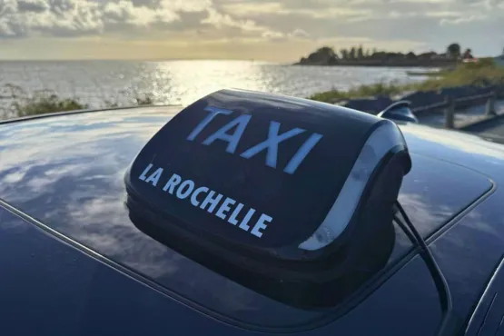 Lumineux Taxi La Rochelle sur un véhicule au bord de l’océan