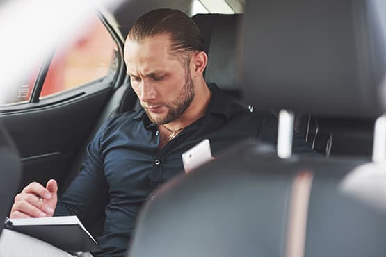 Passager écrivant dans son carnet pendant un déplacement en voiture