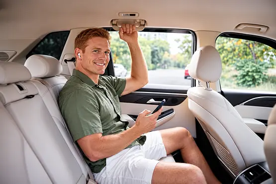 Passager avec un téléphone tenant la poignée au plafond d’une voiture — illustration VTC : Corrèze