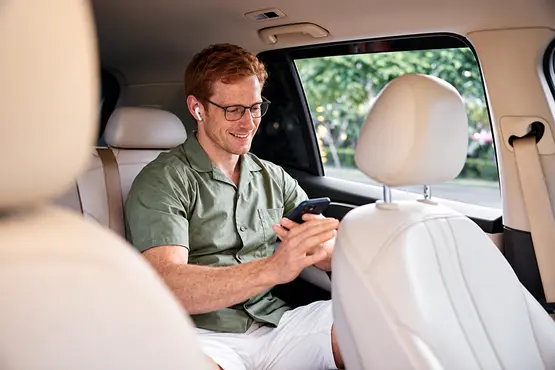 Passager avec des lunettes utilisant son téléphone dans une voiture, illustration VTC en Côte-d’Or