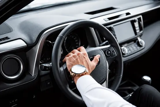 Main sur le volant et tableau de bord d’une voiture — illustration VTC : Gard