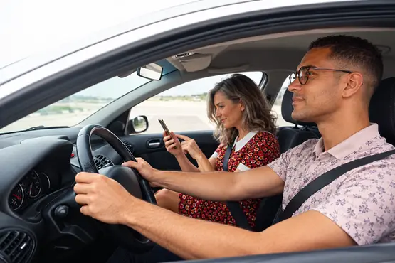 Conducteur et passagère consultant un téléphone dans une voiture, illustration VTC dans la Meuse