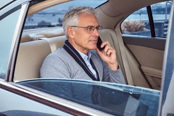 Passager aux cheveux gris au téléphone dans une voiture, illustration VTC en Moselle