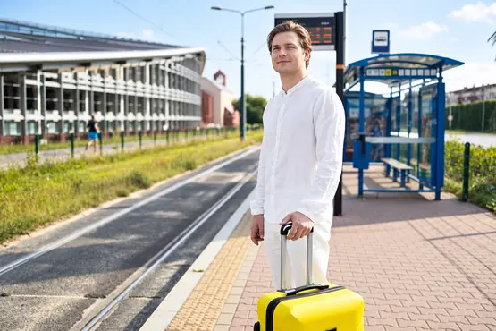 Voyageur avec une valise jaune sur un quai, illustration VTC dans la Nièvre