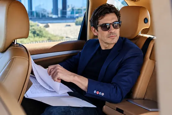 Passager en veste bleue consultant des documents dans une voiture, illustration VTC dans le Bas-Rhin