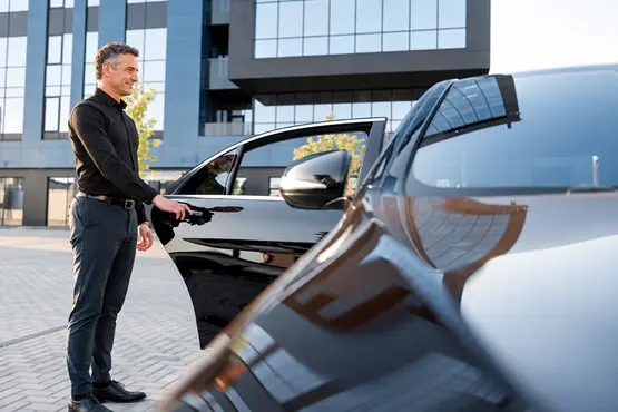 Chauffeur ouvrant la portière arrière d’une berline, illustration VTC à Paris