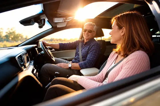 Conducteur et passagère dans une voiture au coucher du soleil — illustration VTC : Seine-Maritime
