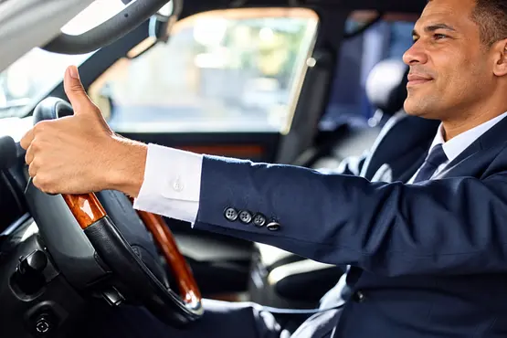 Conducteur en costume levant le pouce dans une voiture — illustration VTC : Vienne