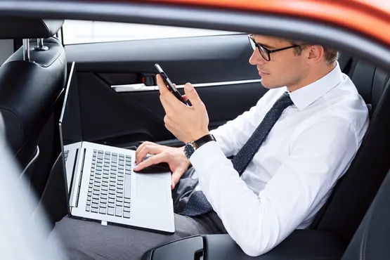 Passager avec un ordinateur portable et un téléphone dans une voiture — illustration VTC : Haute-Vienne