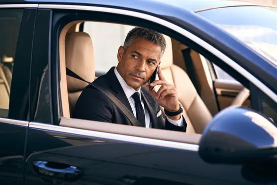 Passager en costume au téléphone dans une voiture — illustration VTC : Saint-Martin